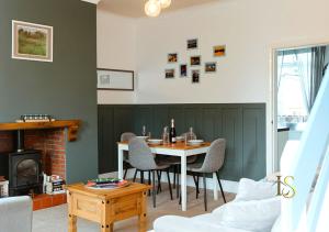 sala de estar con mesa, sillas y chimenea en *Luke Stays Oswald Terrace*, en Stanley