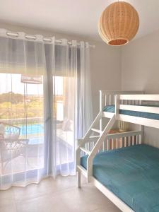 - une chambre avec des lits superposés et une grande fenêtre dans l'établissement Los Flamencos Isla Canela WIFI y AIRE AC. SOLO FAMILIAS Y PAREJAS, à Isla Canela