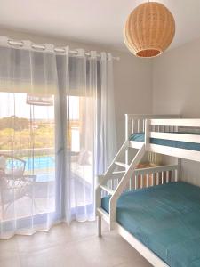 a bedroom with a bunk bed and a large window at Los Flamencos Isla Canela CALEFACCIÓN Y WIFI -SOLO FAMILIAS Y PAREJAS- in Isla Canela