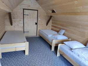 a room with two beds in a log cabin at Chalupa v Okrouhlé Radouni 