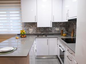a kitchen with white cabinets and a counter top at APARTAMENTO GAEL- PLAZA ESPAÑA in Avilés