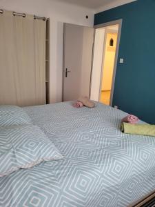 een bed met twee kussens in een slaapkamer bij Les Jacynthes in Colmar
