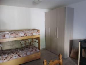 - une petite chambre avec des lits superposés et un placard dans l'établissement monolocale CRIS, à Madesimo