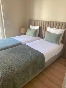 two beds sitting next to each other in a bedroom at Santa Joana Apartments with garden and heated pool in Lisbon