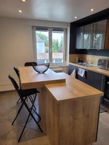 a kitchen with a wooden island in the middle at Les Jacynthes in Colmar