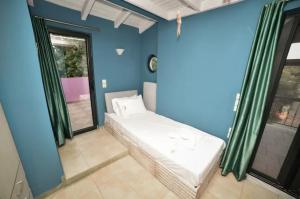 a room with a bed in a room with blue walls at Anastasias Villa in Kastro Kyllini