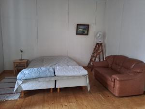ein Wohnzimmer mit einem Bett und einem Sofa in der Unterkunft Tolvi in Harjavalta
