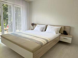 a large bed in a room with a large window at Apartment DUNJA Laktasi in Laktaši +8 photos