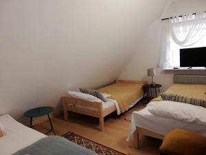 a room with three beds and a television in it at L&B House in Malbork