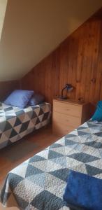 1 dormitorio con 2 camas y pared de madera en Upeslīči atpūtai, en Jelgava