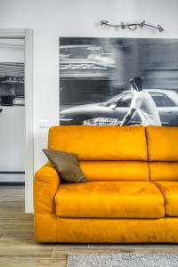 Eine gelbe Couch in einem Raum mit einem Bild eines Mannes in der Unterkunft Grand Maison del Moro - Trastevere in Rom