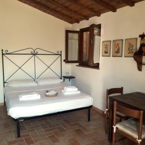 1 dormitorio con cama, mesa y mesa en Agriturismo Poggio Falco Batignano, en Batignano