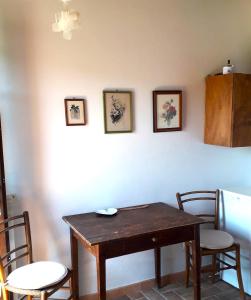 comedor con mesa, sillas y nevera en Agriturismo Poggio Falco Batignano, en Batignano