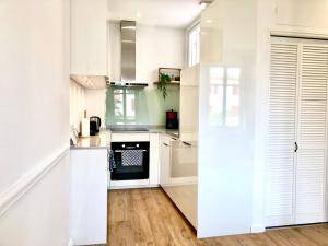 a kitchen with white cabinets and an oven at HYPER-CENTRE-PLAGE - 46m2 - 2 pieces - Rénové 2023 in Saint-Jean-de-Luz