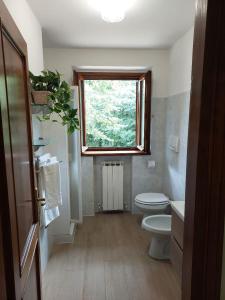 baño con aseo y ventana en Nido Romantico, en Ortignano Raggiolo