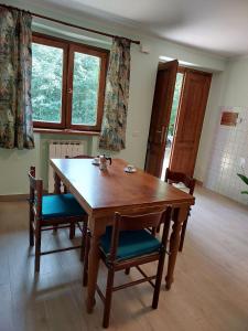 una mesa de madera y sillas en una habitación con ventanas en Nido Romantico, en Ortignano Raggiolo