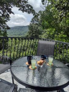stół z dwoma kieliszkami soku na balkonie w obiekcie Kosmajska Vila w mieście Koraćica
