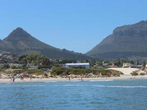 una spiaggia con persone su di essa con montagne sullo sfondo di Dune Lodge a Hout Bay