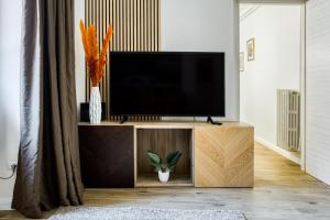einen TV auf einem Holzständer im Wohnzimmer in der Unterkunft Grand Maison del Moro - Trastevere in Rom
