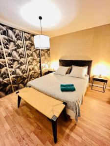 - une chambre avec un lit et un banc dans l'établissement Appartement de Standing Aux Portes de Paris, à Nogent-sur-Marne