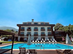 a hotel with a swimming pool in front of a building at My Green Boutique Hotel in Masukiye