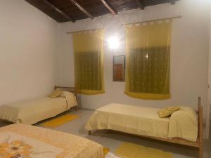 um quarto com duas camas e duas janelas em La casa di Simona em Telti
