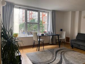 a living room with a table and a large window at Prime Location Apartment - Heart of London in London