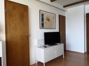 a living room with a television on a white cabinet at Harz-Fewo KY487 in Braunlage