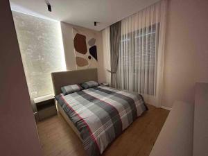 a bedroom with a bed in front of a window at Comfort,excellence. in Kamëz