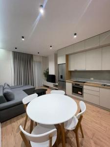 a living room with a white table and white chairs at Comfort,excellence. in Kamëz