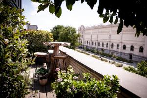 a balcony with a table and some plants and a building at Suite Aux Anges in Antwerp