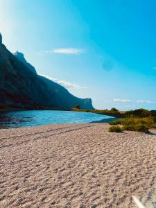 una playa de arena junto a un cuerpo de agua en Casa zona mare, en Oliveri