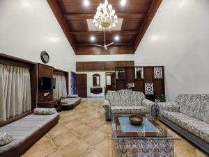uma sala de estar com um sofá e uma mesa em Heaven Villa em Panchgani