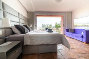 um quarto com uma cama e um sofá roxo em Villa Bellavista II em Portorož