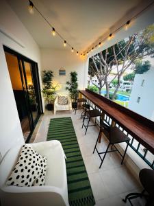balcón con mesa, sillas y alfombra verde en Vilamoura 2 Bedroom with Pool - Na Casa De Pascal, en Vilamoura