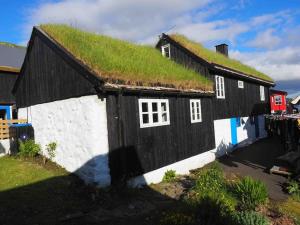 a black and white house with a grass roof at A pearl in the middle of Kvívík with a nice view in Kvívík