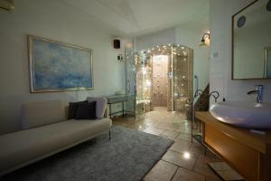 a bathroom with a couch and a sink and a shower at Villa Bellavista II in Portorož