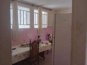 een eetkamer met een tafel en een roze muur bij Hostel Leonardo Quarto com cama de casal in Vitória
