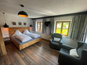 a bedroom with a bed and a couch and a chair at Das Glaagut - Familie Hain in Hochfilzen