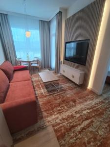 a living room with a red couch and a television at Bel Mare Aqua 2 and Garden F104 in Międzyzdroje