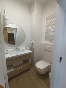 een badkamer met een wastafel, een toilet en een spiegel bij Bel Mare Aqua 2 and Garden F104 in Międzyzdroje