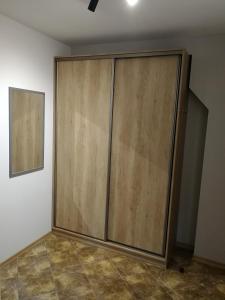 a large wooden door in the corner of a room at Apartament nad Węgorapą in Węgorzewo