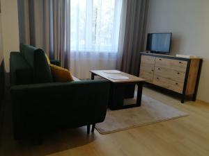 un soggiorno con divano, tavolo e TV di Apartament nad Węgorapą a Węgorzewo