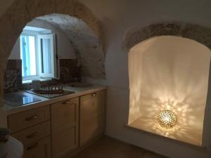 - une cuisine avec un évier et un comptoir lumineux dans l'établissement Trullollero UnPostoNelMondo, à Ceglie Messapica