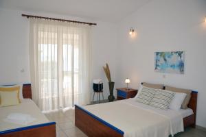 1 dormitorio con 2 camas y ventana en Lappas Rooms en Rovies