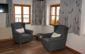 twee stoelen en een televisie in de woonkamer bij Das Glaagut - Familie Hain in Hochfilzen