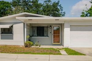 een wit huis met een garage bij Cozy 3Bdr home in the heart of Tampa in Tampa