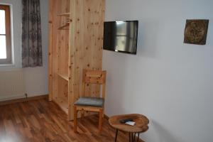 Una habitación con una silla y un televisor en la pared. en Das Glaagut - Familie Hain, en Hochfilzen 42 fotos más
