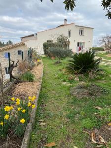 een tuin met gele bloemen en een wit huis bij Sous le Tilleul in Saint-Maurice-de-Cazevieille