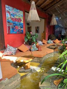 uma sala de estar com um lago de peixes no chão em Mais Que Nada Itacaré - Hostel, Bar & Breakfast em Itacaré